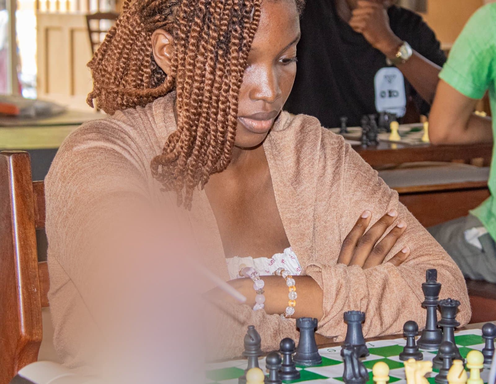 Omotola en tournoi, le regard sur l’échiquier, les pièces noires alignées devant elle.