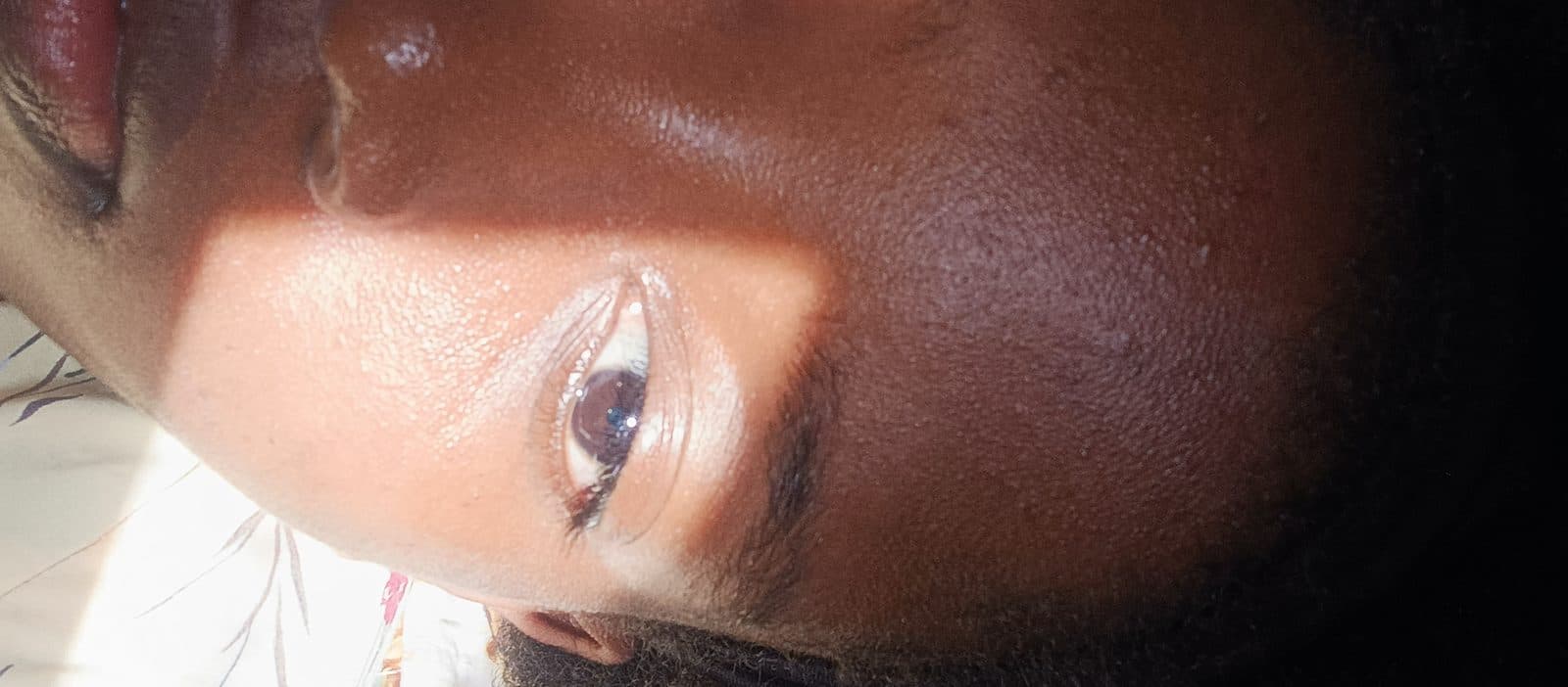 Gros plan sur un regard, la lumière rasant la pommette.