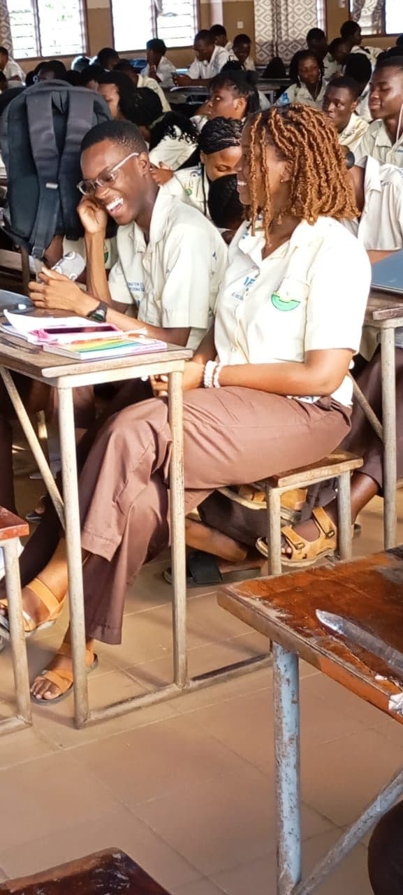 Une salle de cours pleine, les étudiants penchés sur leurs tables.