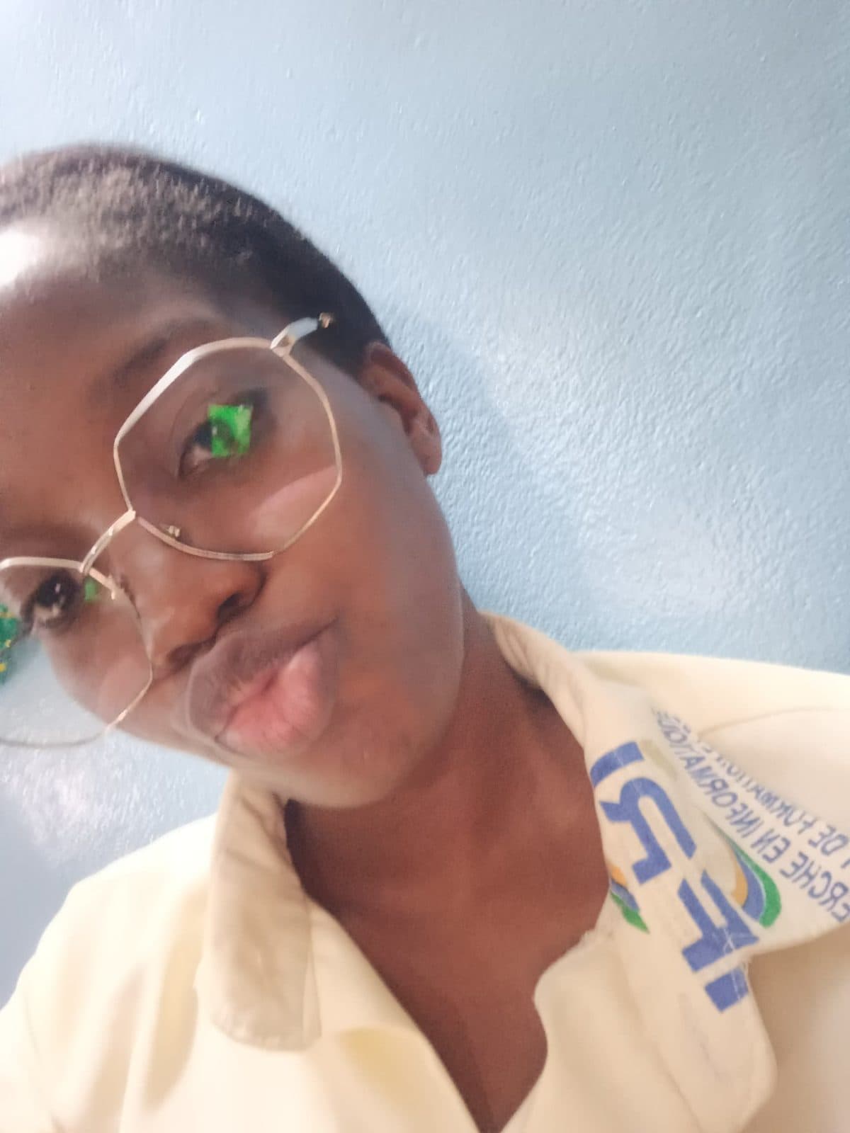 Omotola en selfie, lunettes rondes et polo de l’IFRI.