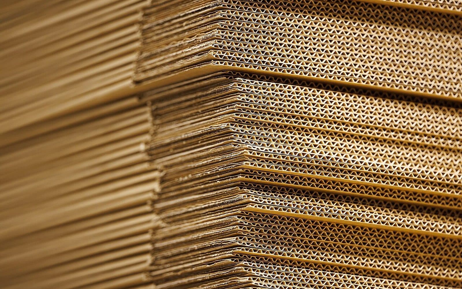 Une pile de cartons ondulés vue de la tranche, en gros plan.